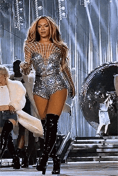 Woman Standing On Stage In Jumpsuit And Boots GIF
