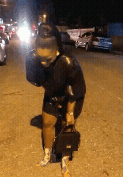 Woman Standing On Street Holding Purse GIF
