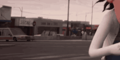 Woman Standing On Street In Front Of Building GIF
