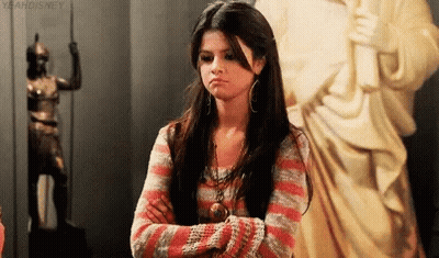 Woman Standing With Crossed Arms In Front Of Statue GIF