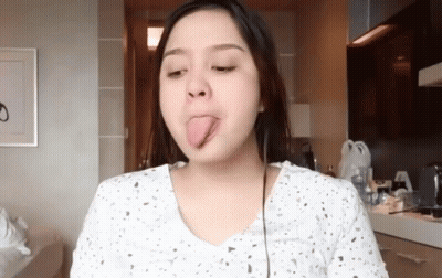 Woman Sticking Tongue Out In Kitchen GIF
