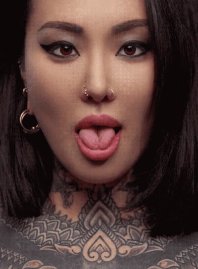 Woman Sticking Tongue Out With Nose Ring And Chest Tattoo GIF