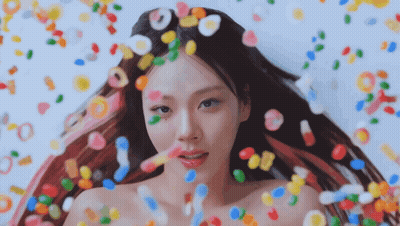 Woman Surrounded By Colorful Candies And Candy Drops GIF