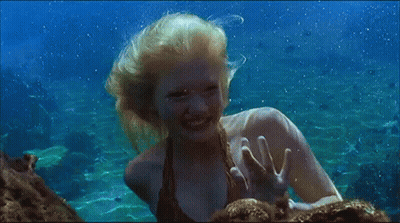 Woman Swimming In Ocean Waving At Camera GIF