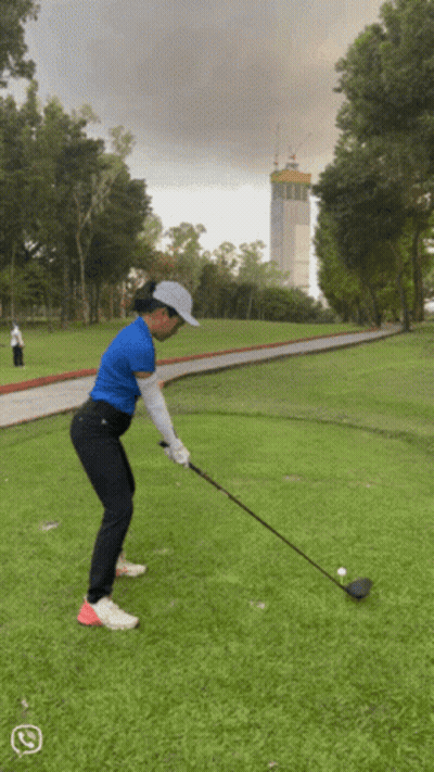 Woman Swinging Golf Club At Ball GIF