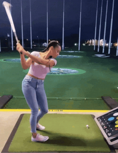 Woman Swinging Golf Club At Golf Ball GIF