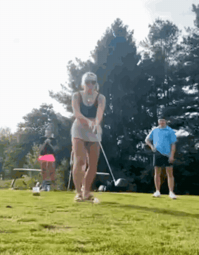Woman Swinging Golf Club On Course GIF