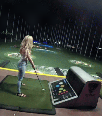 Woman Swinging Golf Club On Golf Course At Night GIF