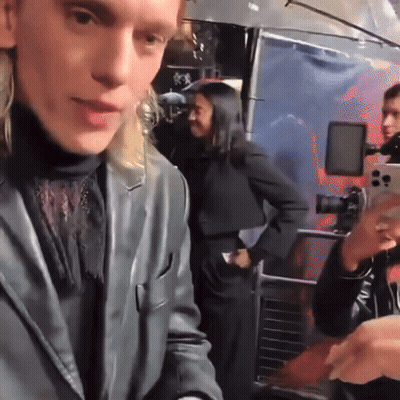 Woman Taking Picture Of Man In Black Suit GIF