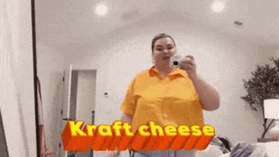 Woman Taking Selfie In Front Of Kraft Cheese Sign GIF