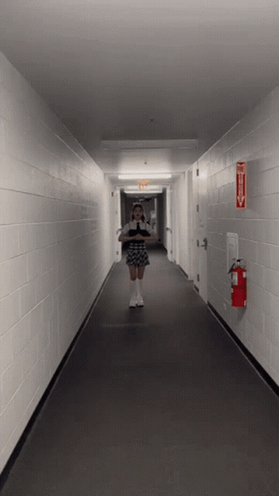 Woman Taking Selfie In Hallway With Fire Extinguisher GIF