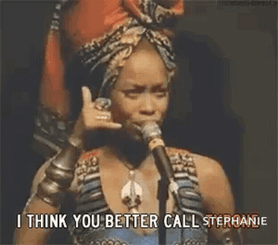 Woman Talking Into Microphone With Head Scarf And Bracelets GIF