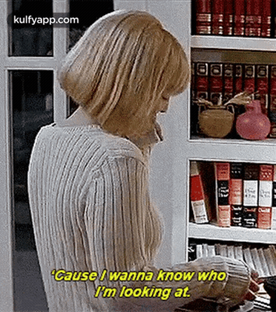 Woman Talking On Phone In Front Of Bookshelf GIF