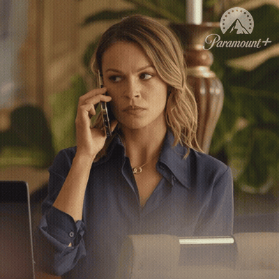 Woman Talking On Phone In Front Of Paramount Sign GIF