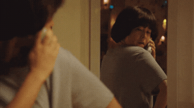 Woman Talking On Phone Looking In Mirror GIF