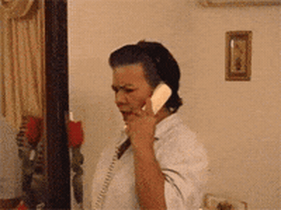 Woman Talking On Telephone In Living Room GIF