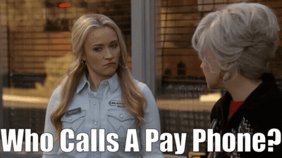 Woman Talking to Another Woman Saying Who Calls a Pay Phone