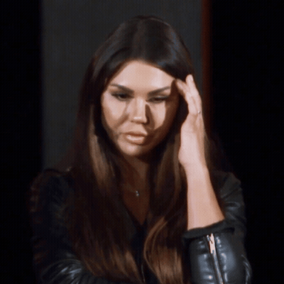 Woman Touching Forehead In Black Leather Jacket GIF