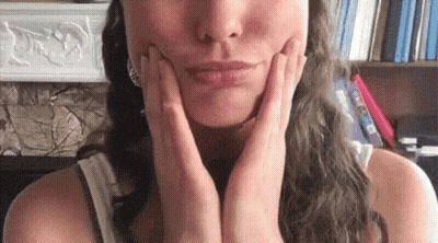 Woman Touching Her Face With Hands GIF