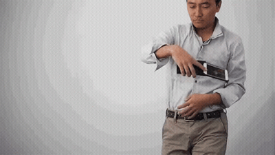 Woman Walking Down Hallway Holding Camera GIF