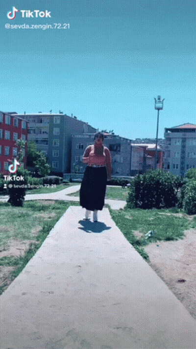 Woman Walking Down Path With TikTok Watermark GIF