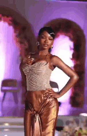 Woman Walking Down Runway Hands On Hips Purple Background GIF