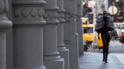 Woman Walking Down Sidewalk in Front of Coco Chanel