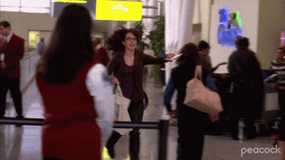 Woman Walking In Airport With Peacock GIF