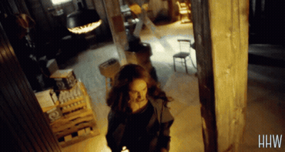 Woman Walking in Dark Room With Letters HW