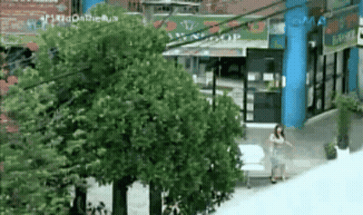 Woman Walking In Front Of Building With Smas Sign GIF