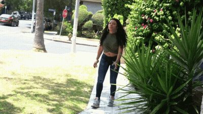 Woman Walking Past Stop Sign GIF