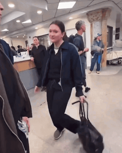 Woman Walking With Bag In Hospital Lobby GIF