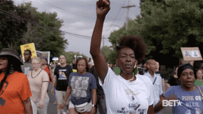 Woman Walking With Fist In Air GIF