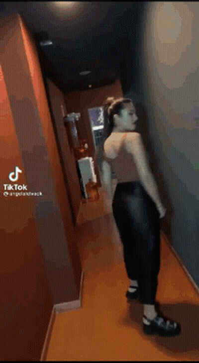 Woman Walking With Windblown Hair And Black Pants GIF