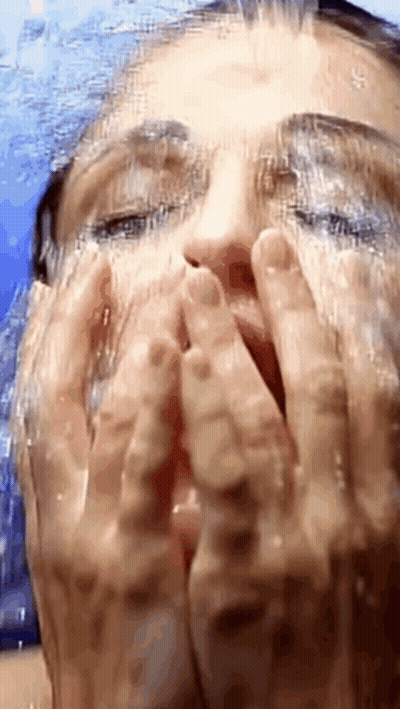 Woman Washing Face Under Shower Head GIF