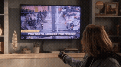 Woman Watching Protests On TV GIF