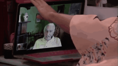 Woman Waving At Older Man On Screen GIF