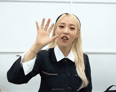 Woman Waving Hand In Headband And Black Jacket GIF