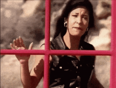 Woman Waving In Front Of Pink Phone Booth GIF
