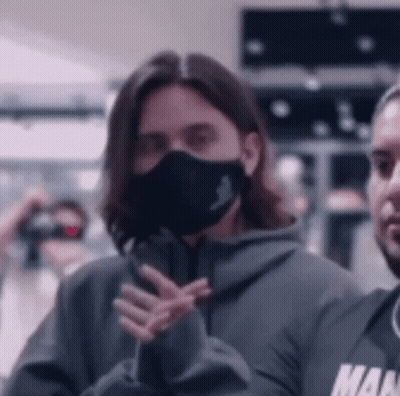 Woman Wearing Face Mask Next To Man In Hoodie GIF