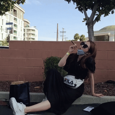 Woman Wearing Fila Fanny Pack Sits On Curb GIF