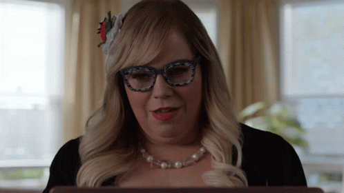 Woman Wearing Glasses And Pearl Necklace Looks At Laptop GIF
