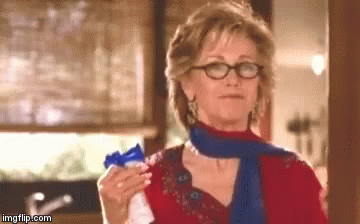 Woman Wearing Glasses And Scarf Holding Something GIF