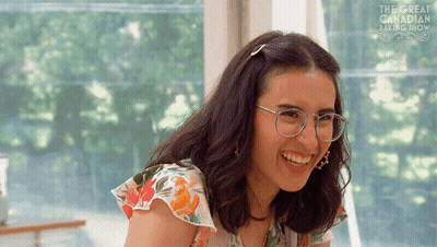 Woman Wearing Glasses Smiling in Front of Great Canadian Baking Show