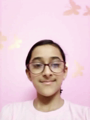 Woman Wearing Glasses Smiling In Front Of Pink Wall With Butterflies GIF