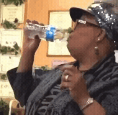 Woman Wearing Hat and Glasses Drinking Water