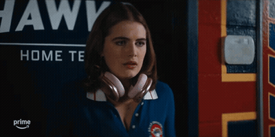 Woman Wearing Headphones In Front Of Awks Sign GIF