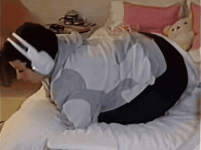 Woman Wearing Headphones Laying On Bed GIF