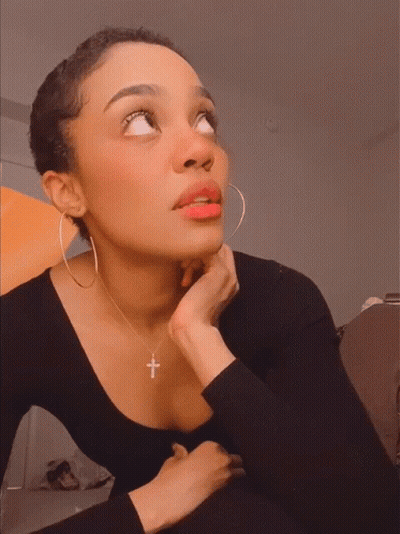 Woman Wearing Hoop Earrings And Cross Necklace Looking Up GIF