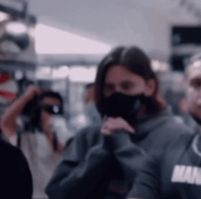 Woman Wearing Mask And Man In Hoodie GIF